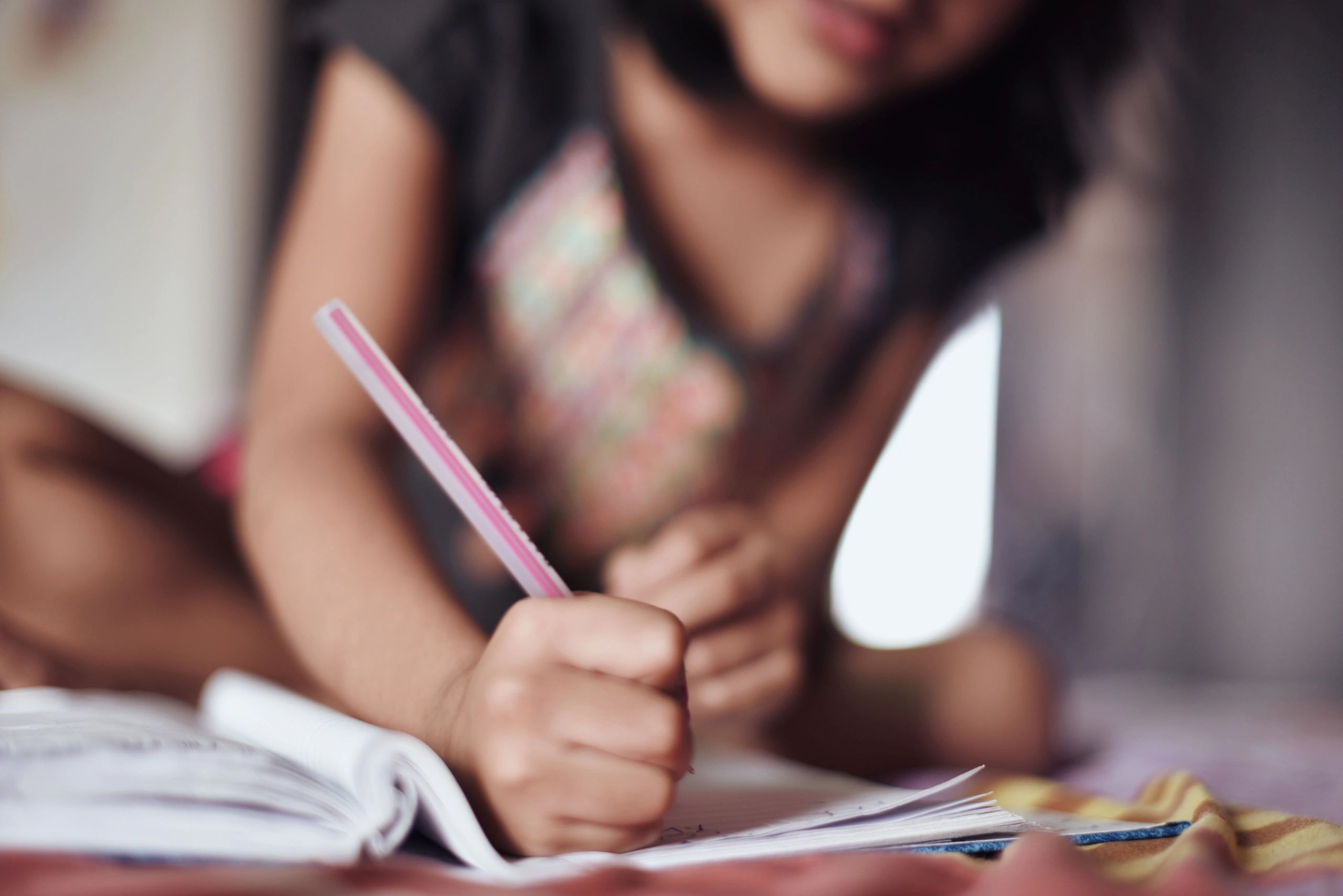 Young learner writing carefully in a notebook