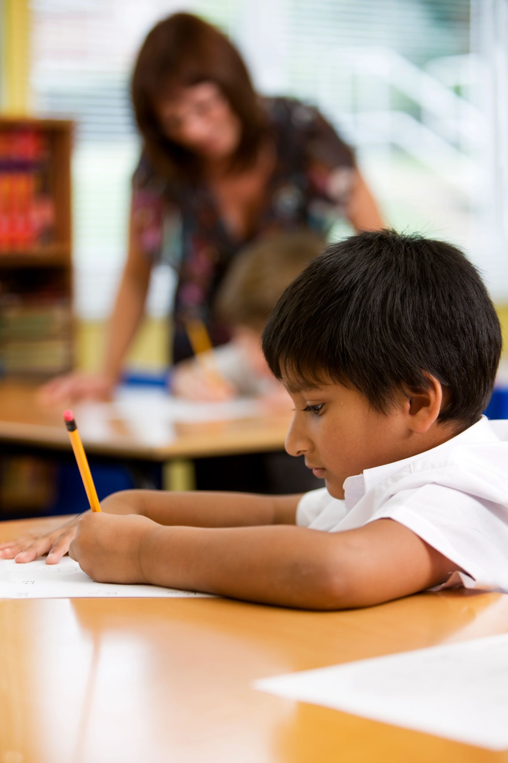 Child concentrating while writing at a desk