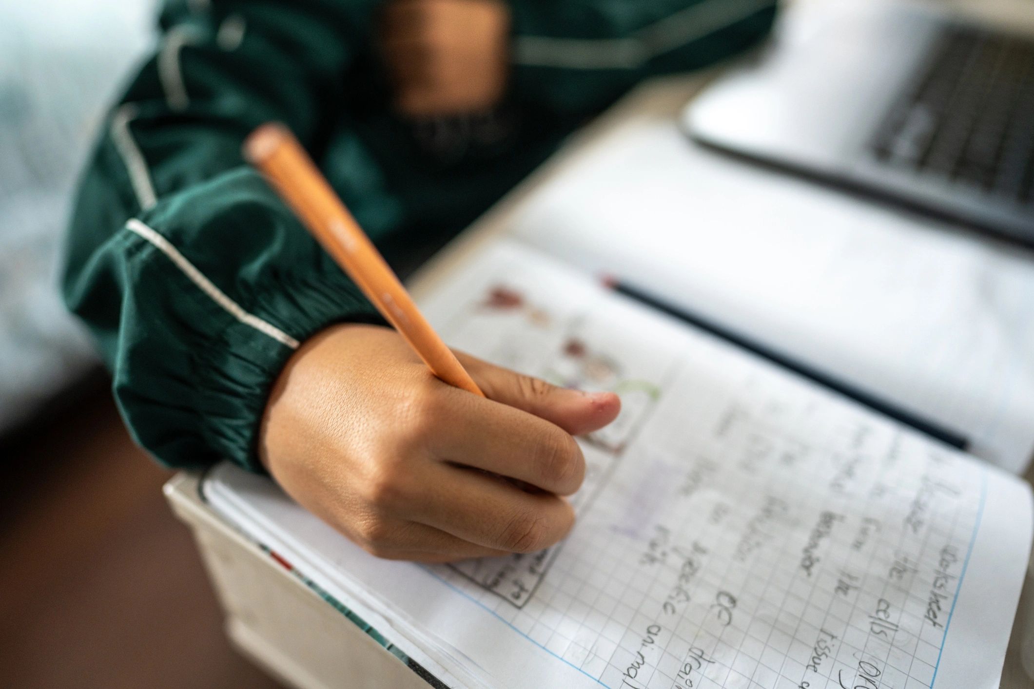 Child's hands writing in a notebook