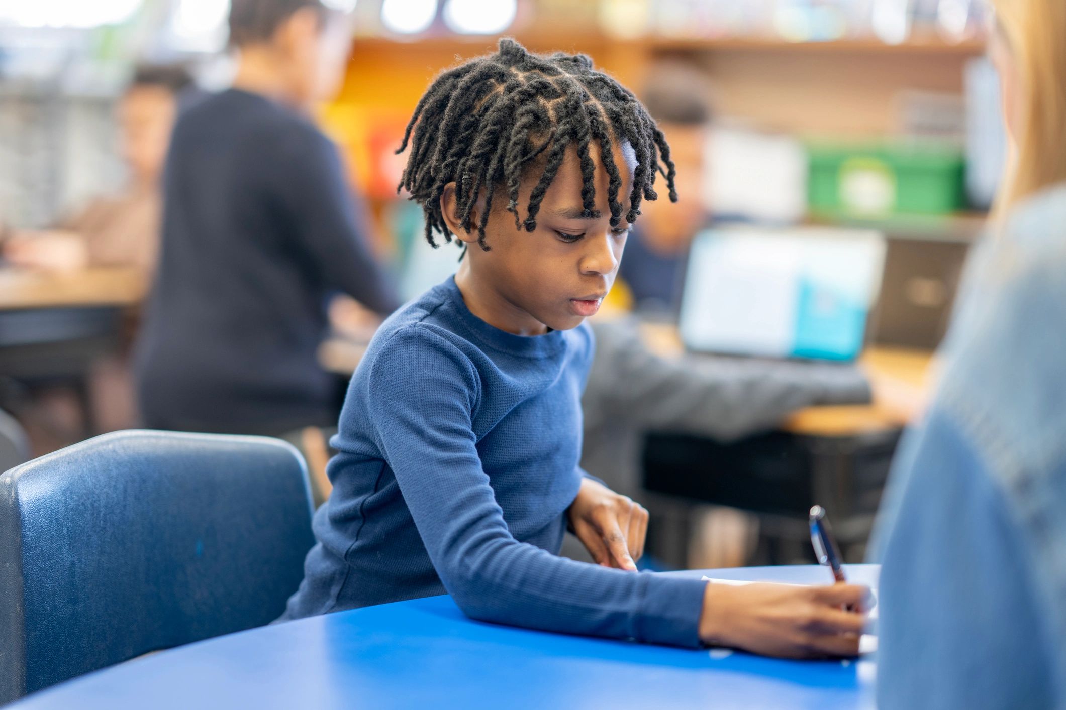 Student practicing handwriting in a classroom